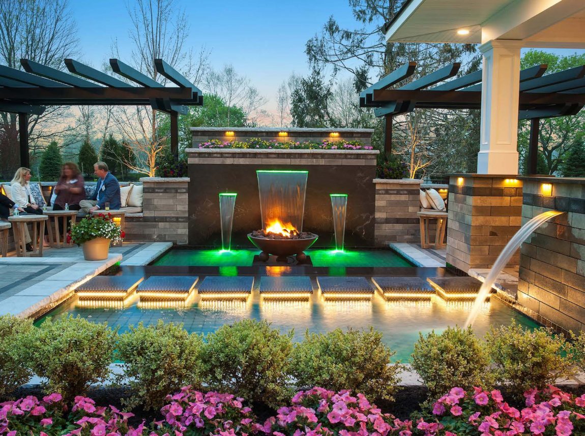 backyard pool with fountains and lighting
