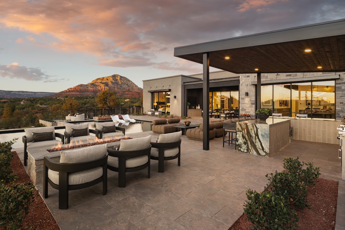 luxury outdoor living space with firepit and bar area overlooking the mountains