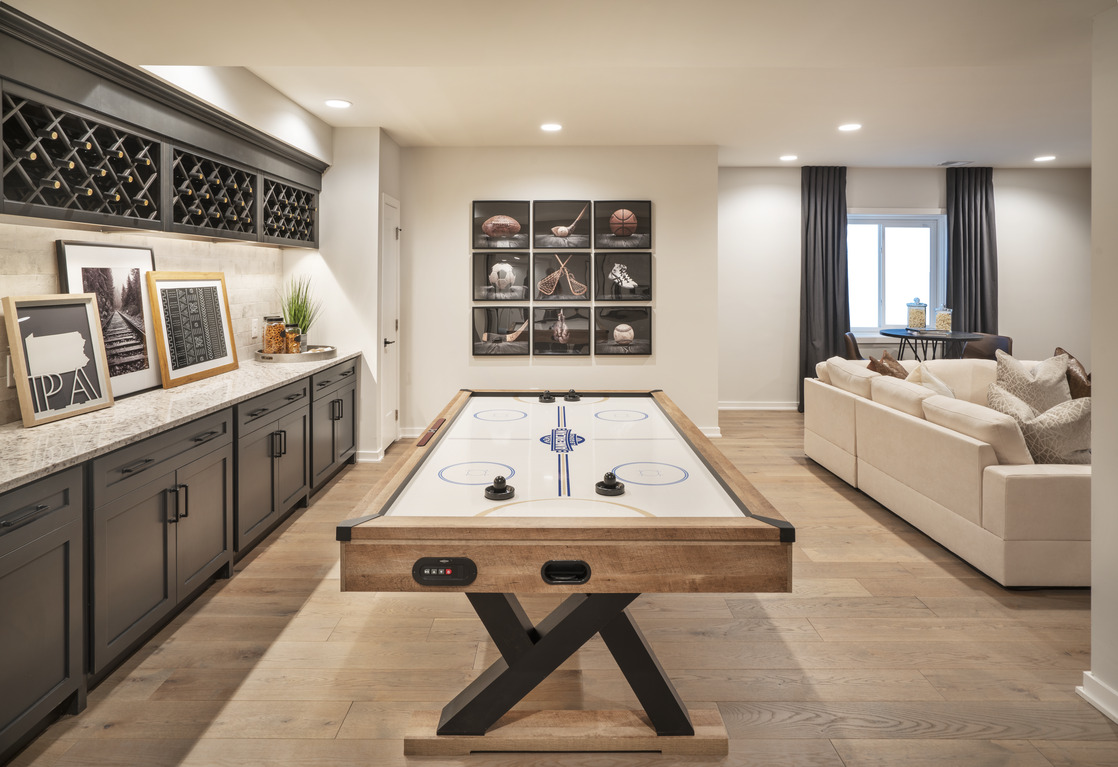 Air hockey table in finished basement with wine cabinets
