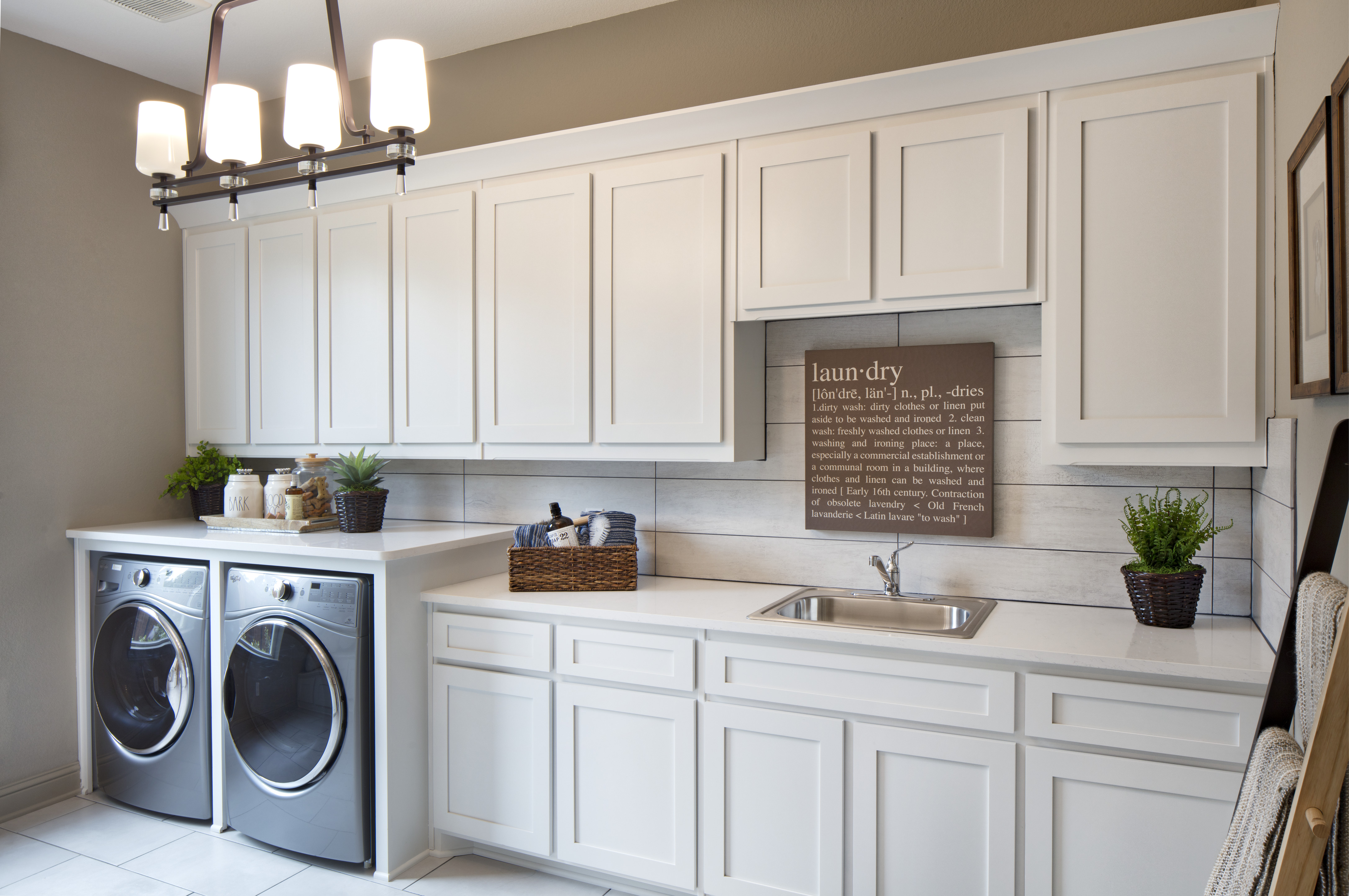 Mudroom with washer and dryer and white cabinets