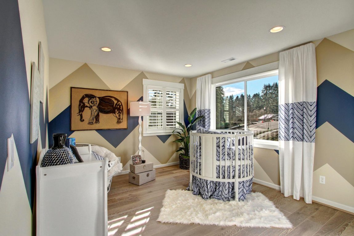 Baby room with a blue patter painted on the wall.