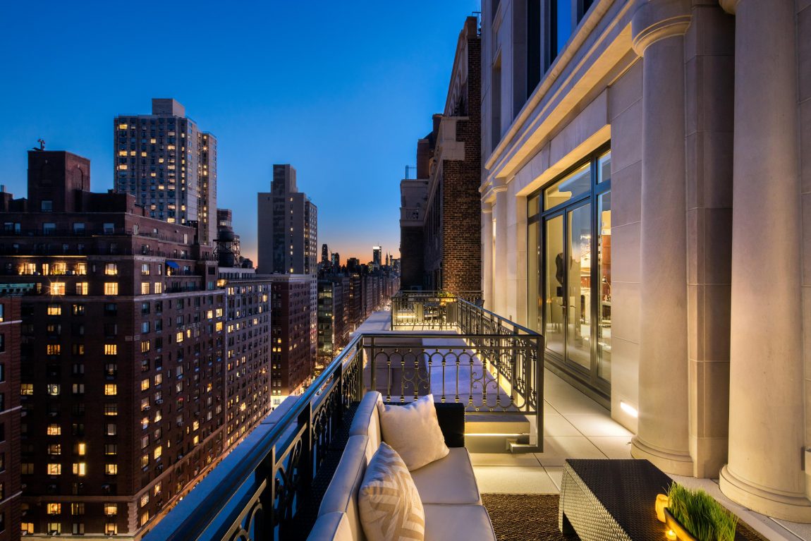 A highly elevated terrace overlooking adjacent cityscape at night.