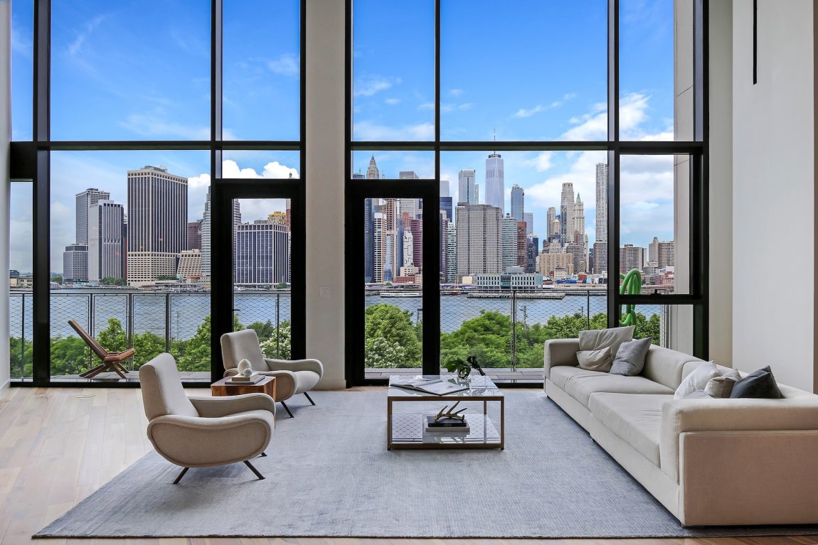 A modern living room with a view of the New York City skyline from across the river