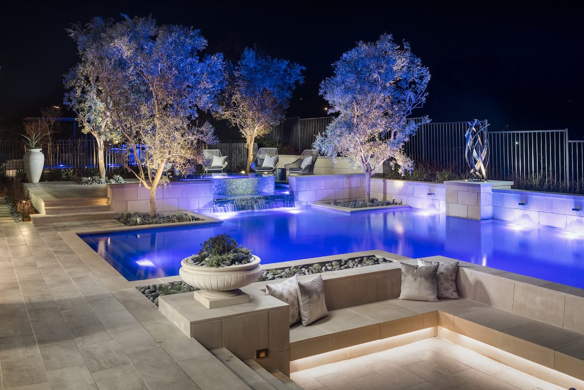 Beautiful landscaping featuring an outdoor pool with sitting area. 