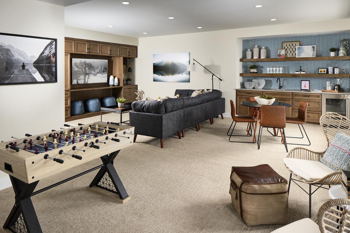 Finished basement with foosball table and sitting areas with television