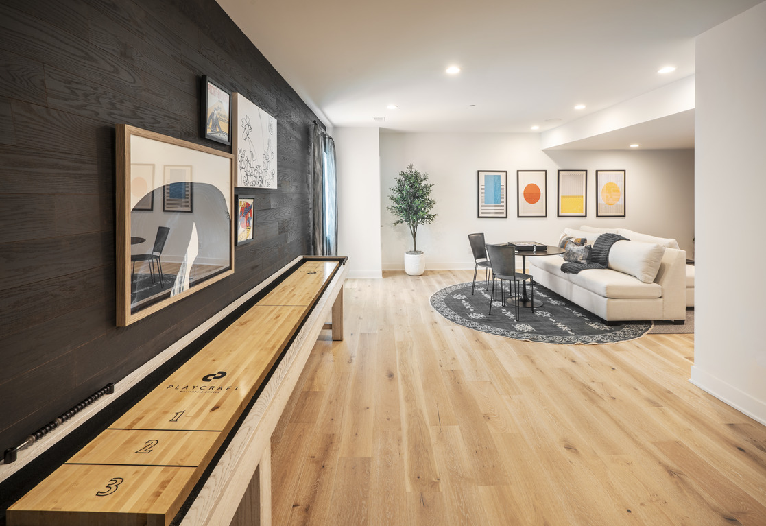 Earth toned basement with shuffleboard table