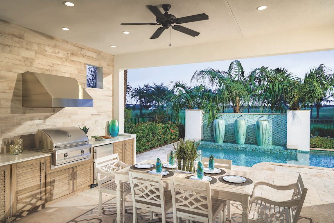 Outdoor kitchen with pool and dining table. 