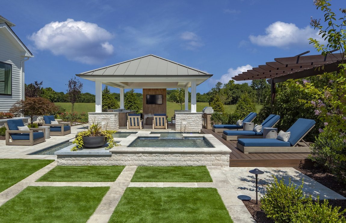 Patterned lawn with outdoor bar, pool and lounge chairs. 