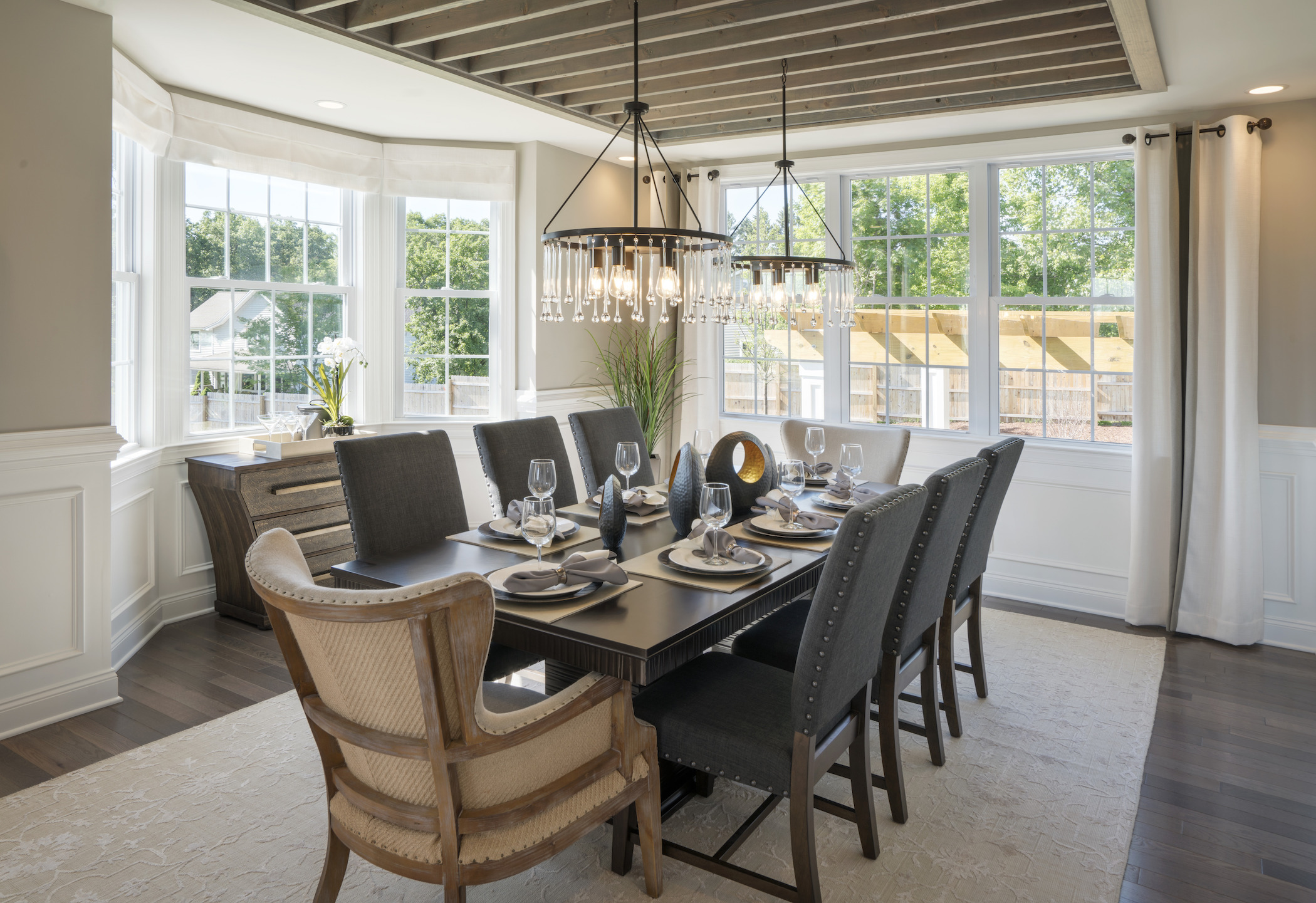 Formal dining room featuring matching pendant fixtures and plenty of natural lighting.