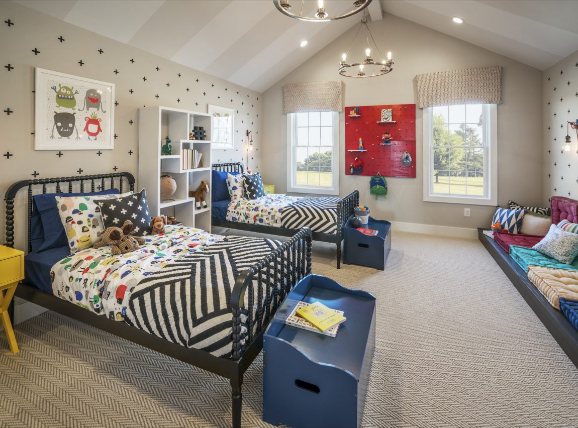 Spacious kids bedroom featuring two eye-catching beds and large chests for storage.