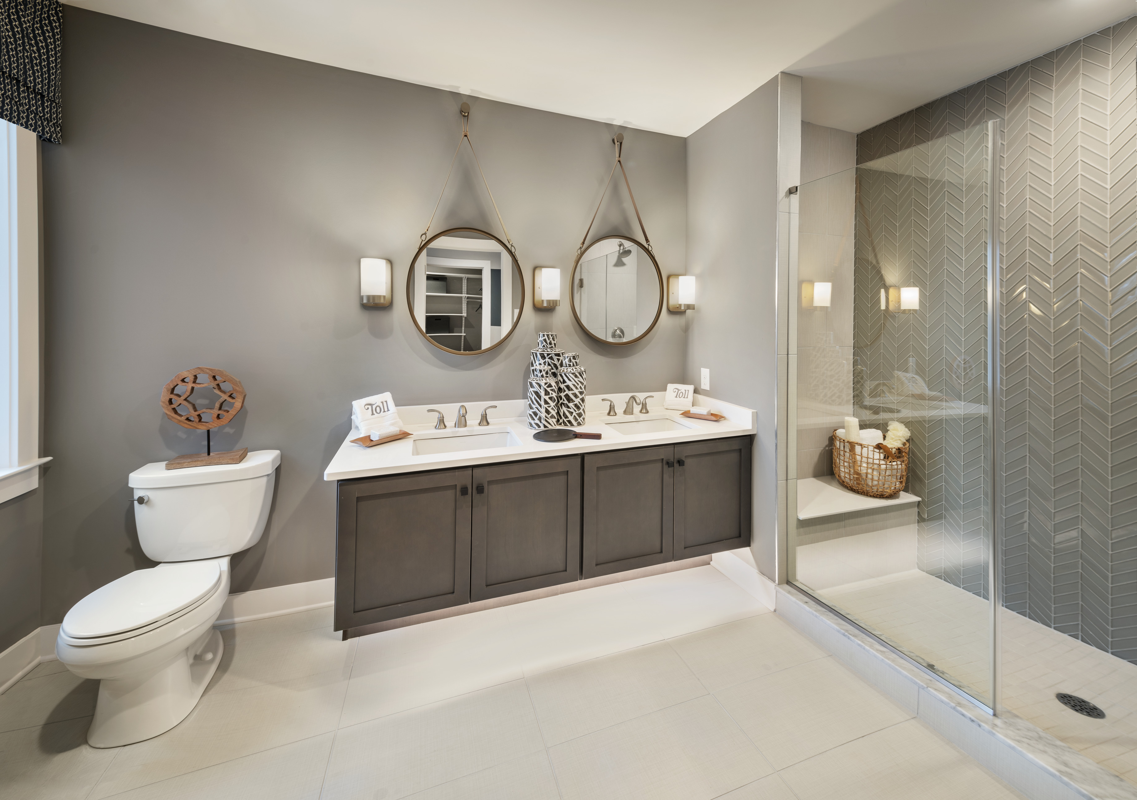 Bathroom with Repose Gray painted walls, dual vanity, toilet, and walk-in shower.