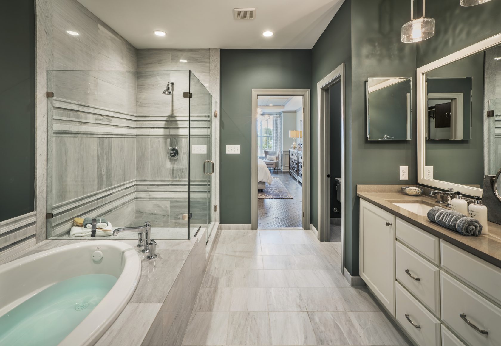 Bathroom with striking green wallls, walk-in shower, bathtub, vanity, and marble flooring