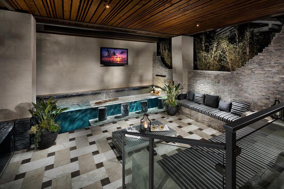 Indoor to outdoor pool bar with wall couch sitting area.