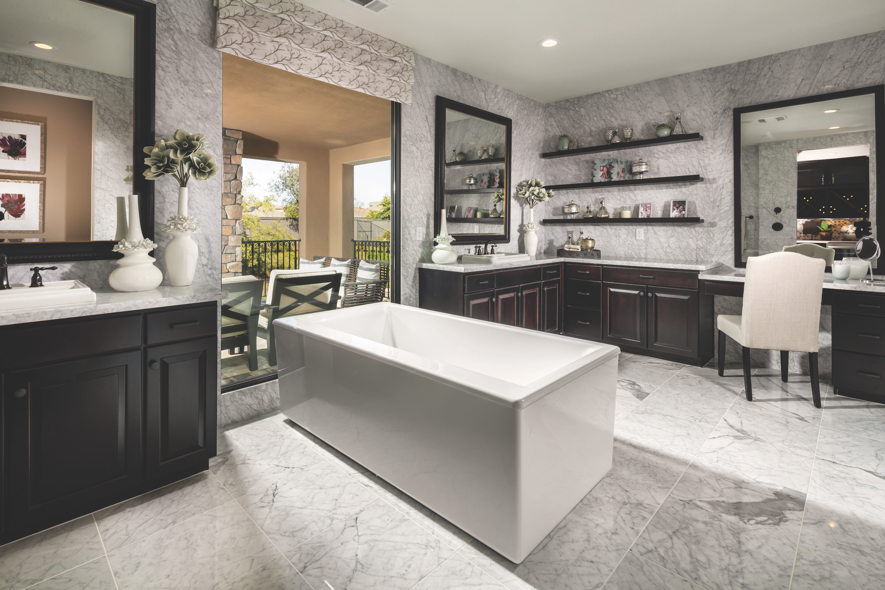 Marble bathroom with freestanding bathtub and bold black vanity cabinets.