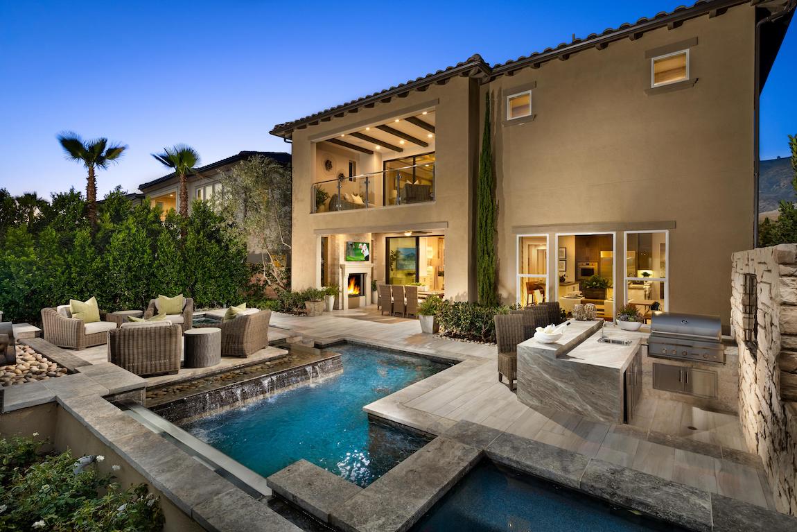 Backyard with pool and outdoor kitchen and styled seating area.