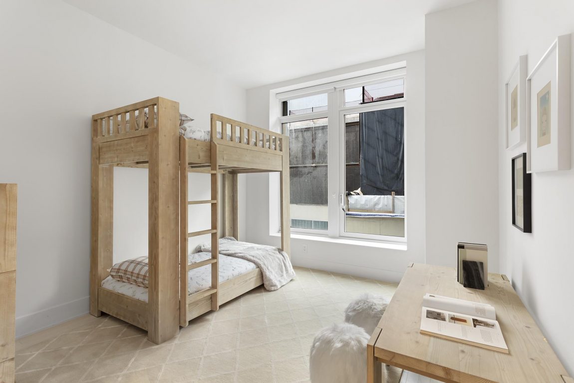 Simple yet elegant kids bedroom featuring wooden bunk bed.