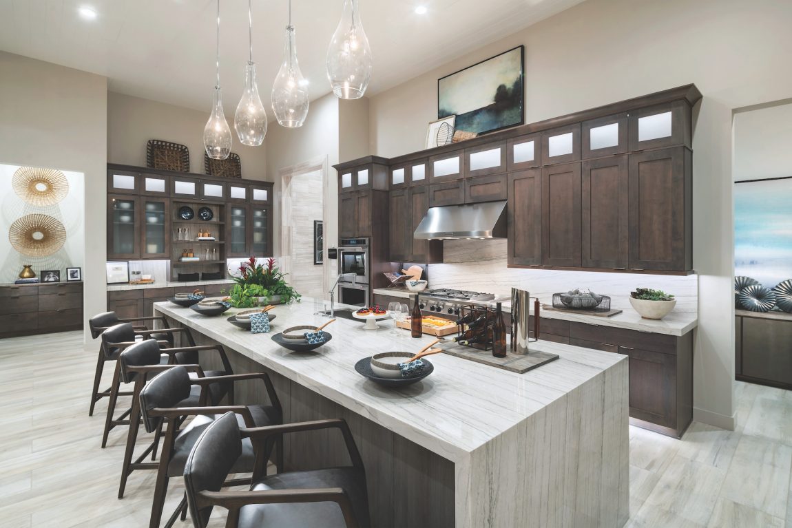 Spacious kitchen featuring long, large island and dark-toned cabinetry.
