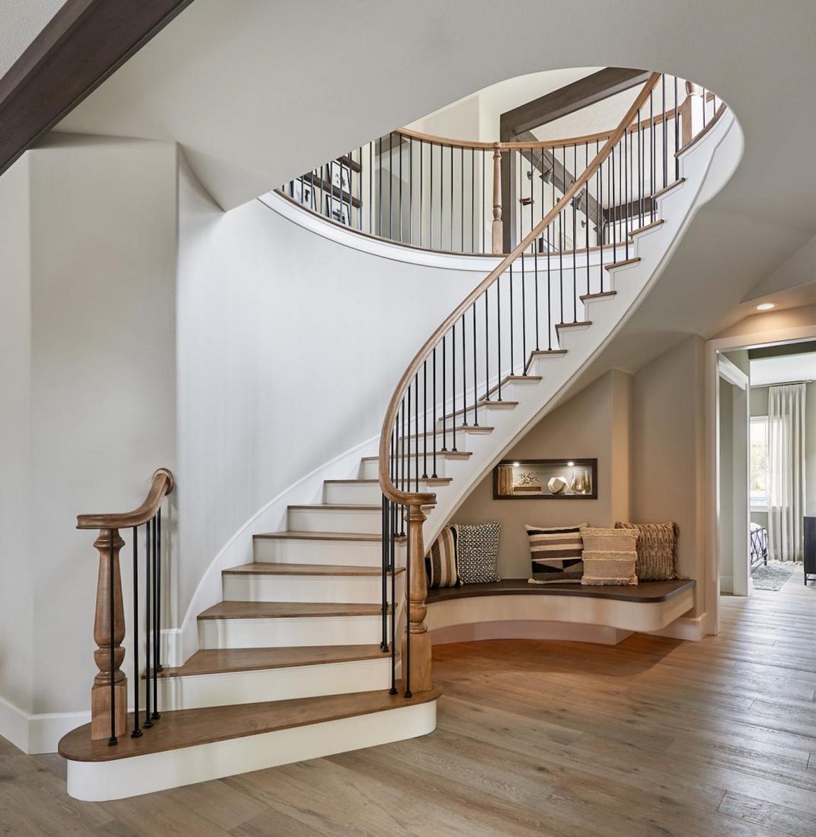 Circular, two-toned staircase featuring nook underneath.