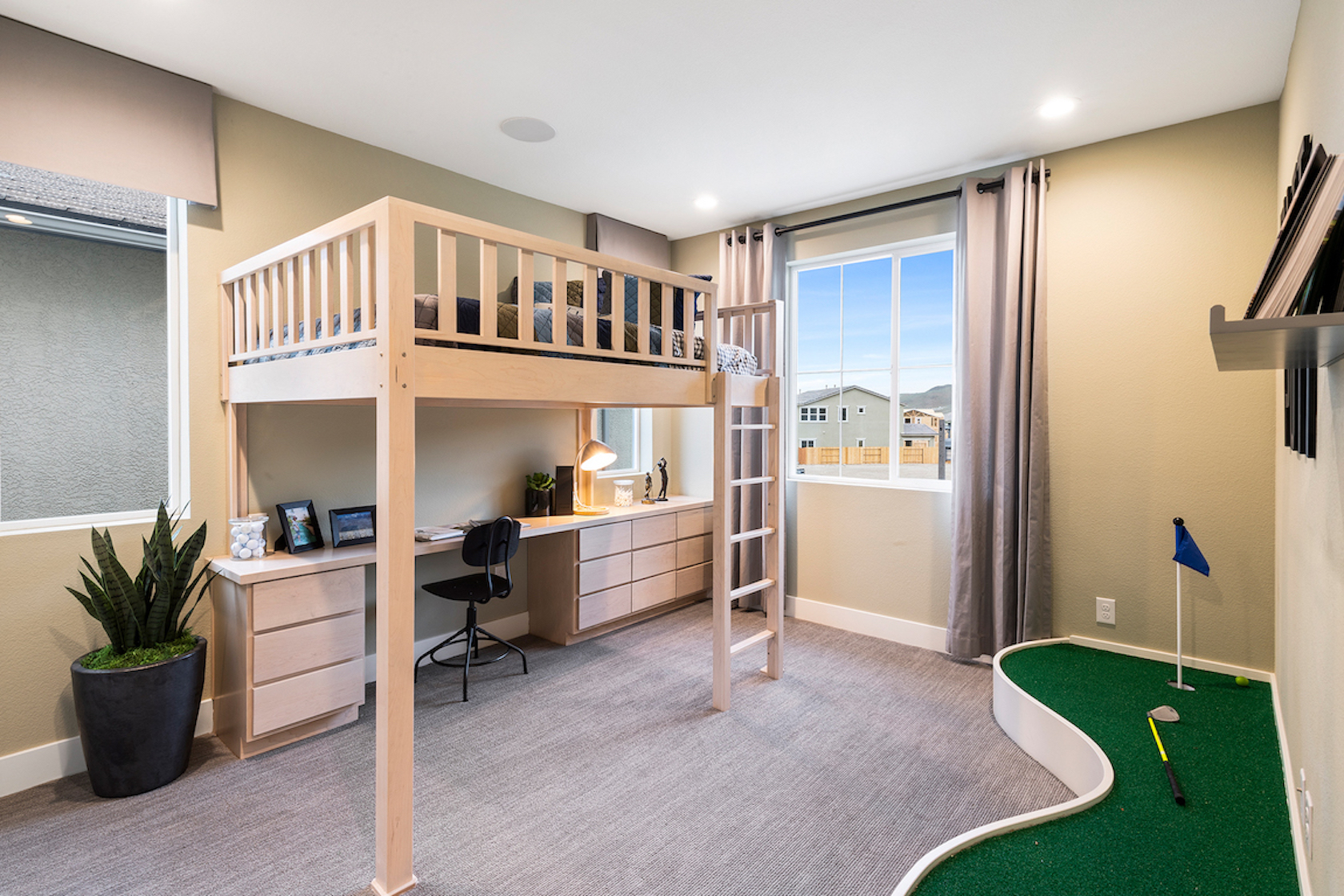 Teen bedroom with loft bed, workspace, and putting green