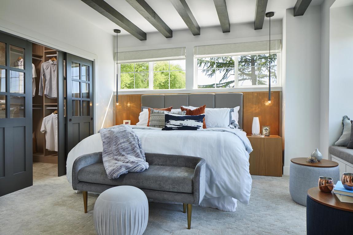 master bedroom with beam ceiling and walk-in closet