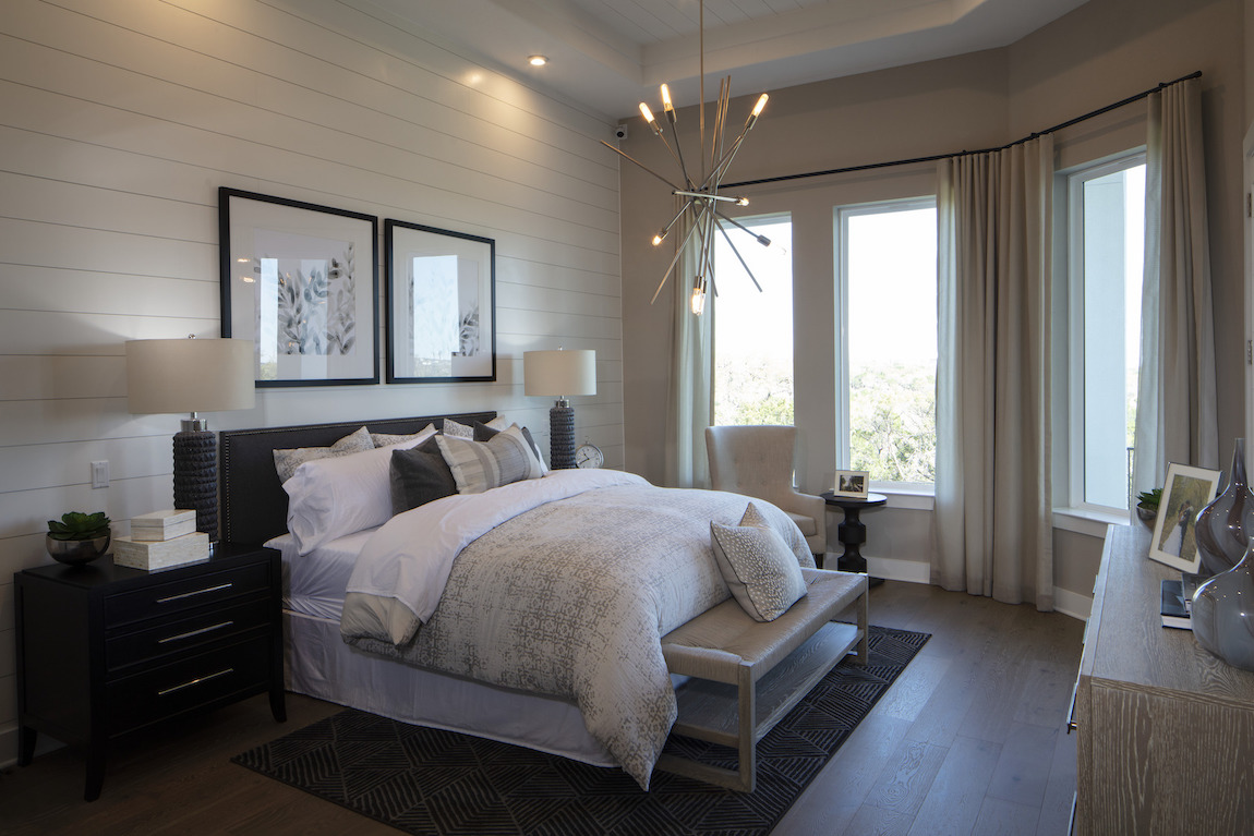 Bedroom with neutral tones & accent shiplap walls.