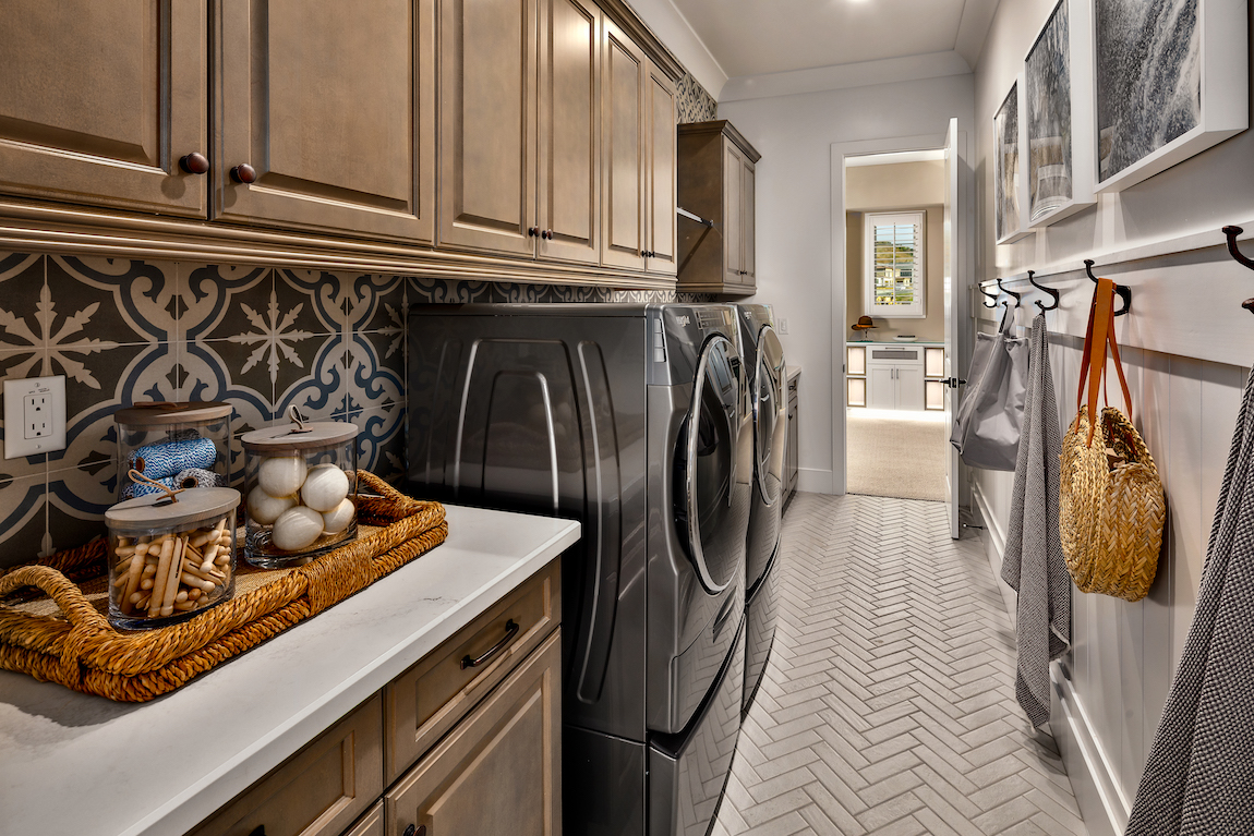 Laundry room with backsplash and brown cabinets
