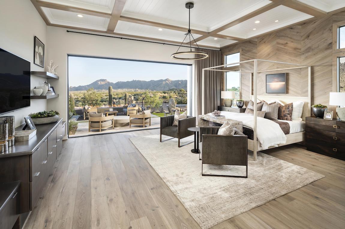 Luxe master bedroom featuring coffered ceiling and seamless transition to outdoors