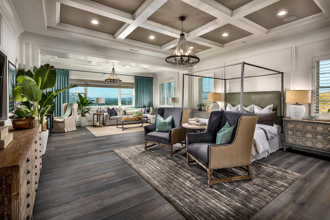 Luxe master bedroom highlighted by coffered ceiling and lounge area