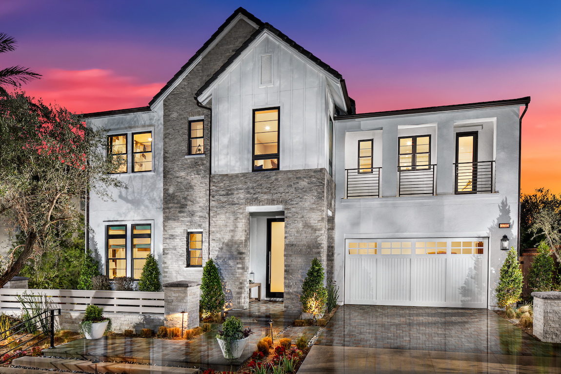 Sleek modern home with white exterior, stone detail and shiplap garage door. 