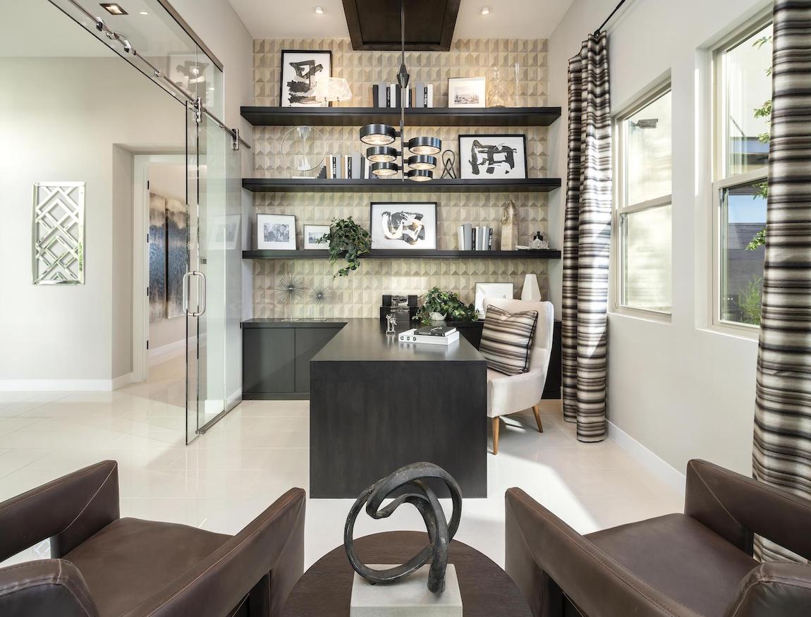 Office with glass doors and a 3-d geometric patterned accent wall.