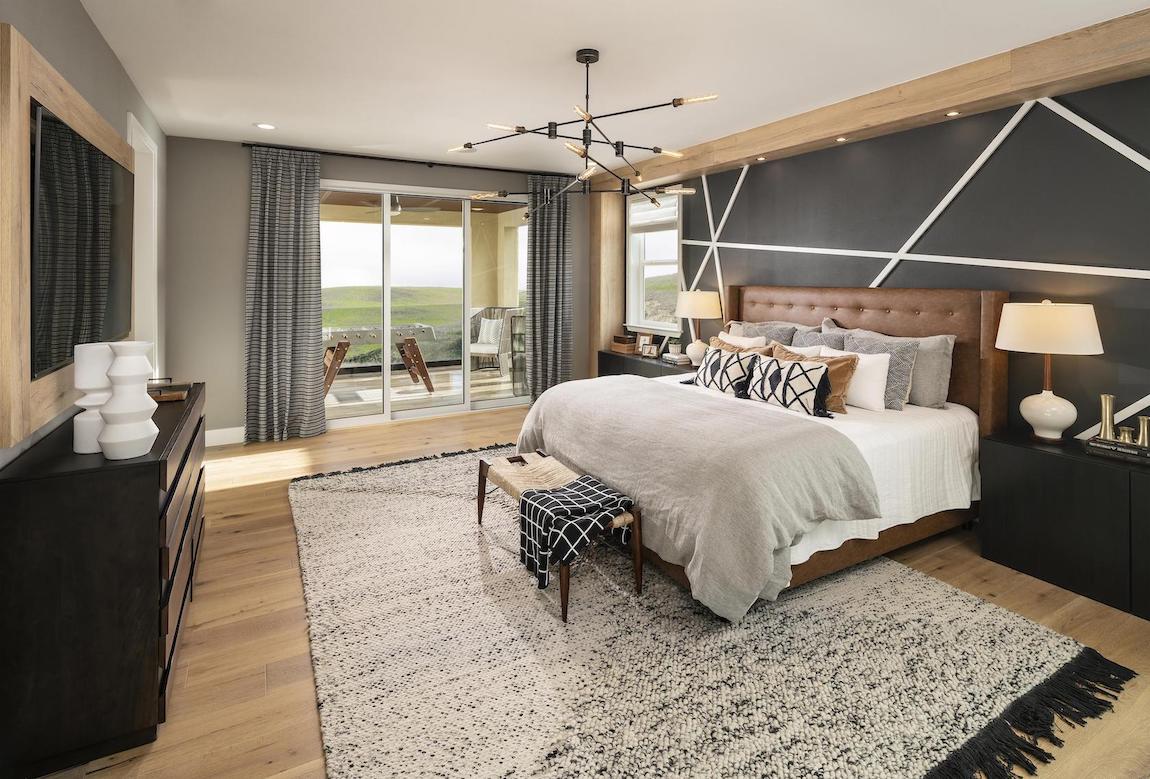 Bedroom with leather headboard and black accent wall with white stripe.