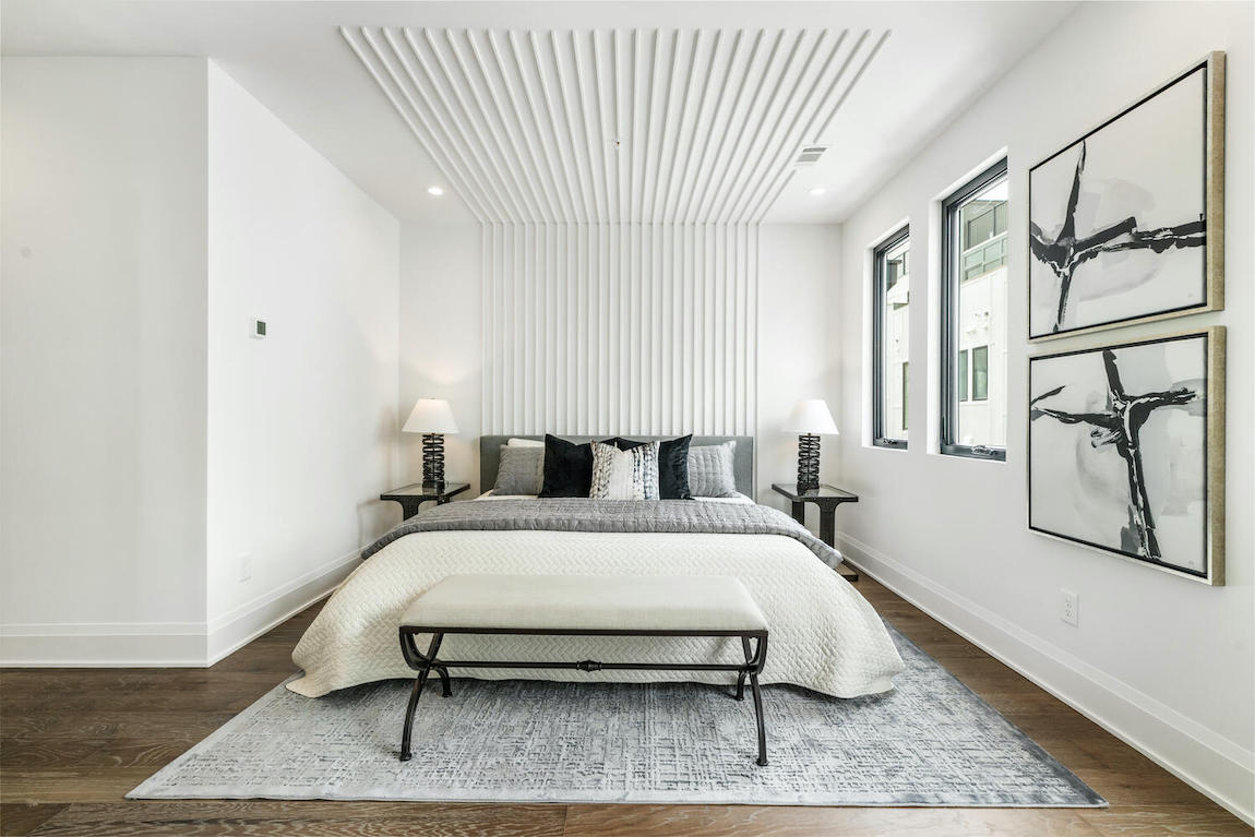 White bedroom design with panel wood accents as headboard with white and black color scheme