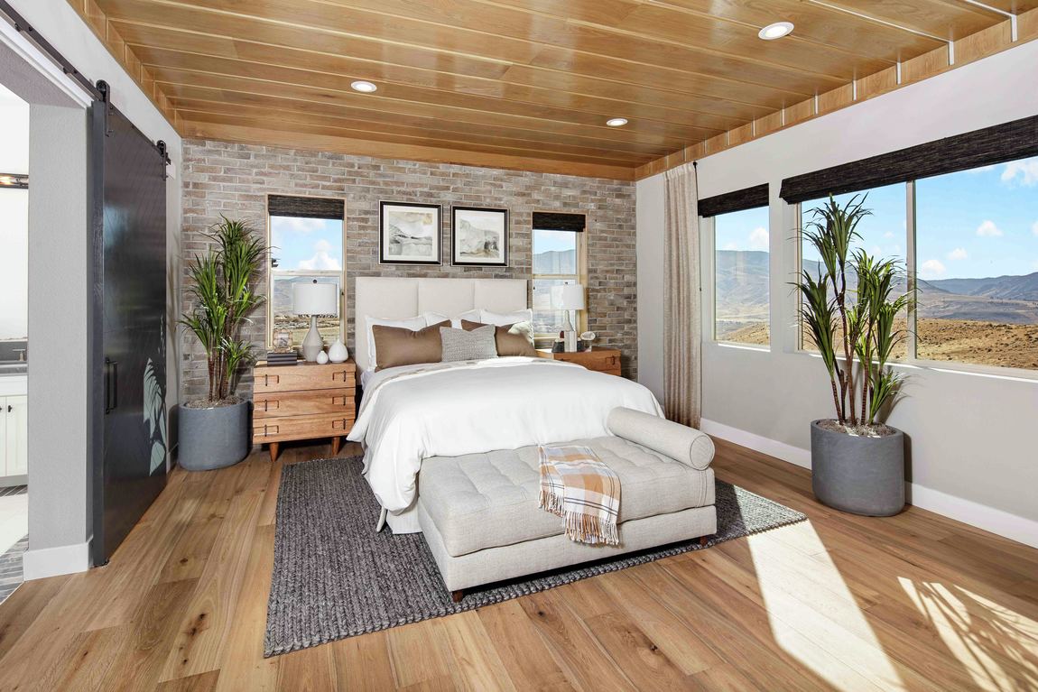 Warm brick accent bedroom design with recessed lighting and wood paneled ceiling