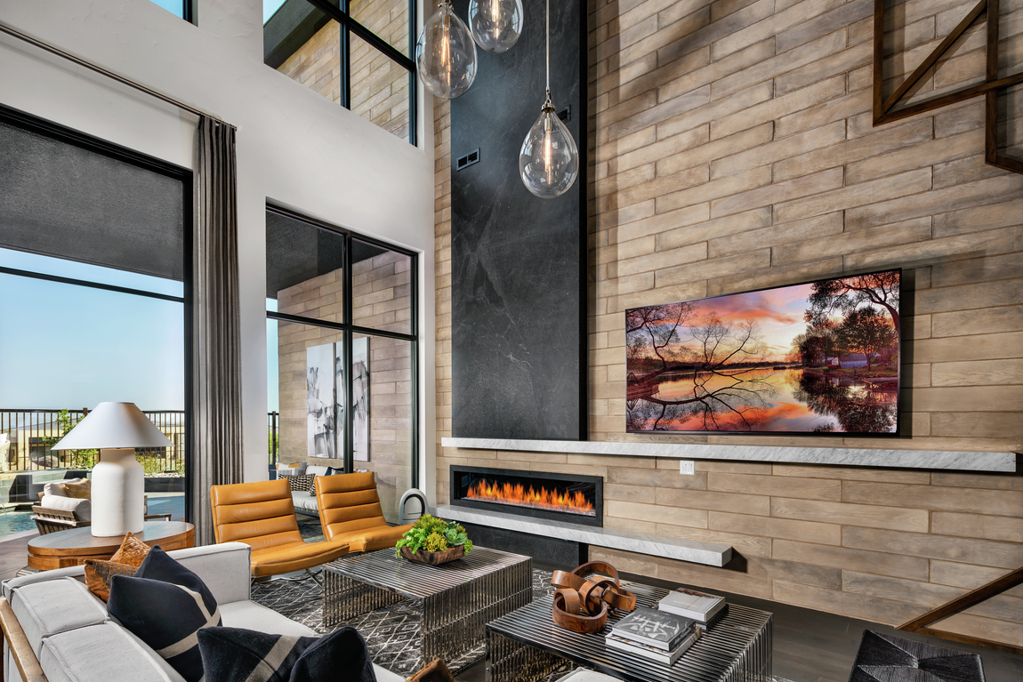 Living room with brick accent wall, fireplace and leather retro chairs