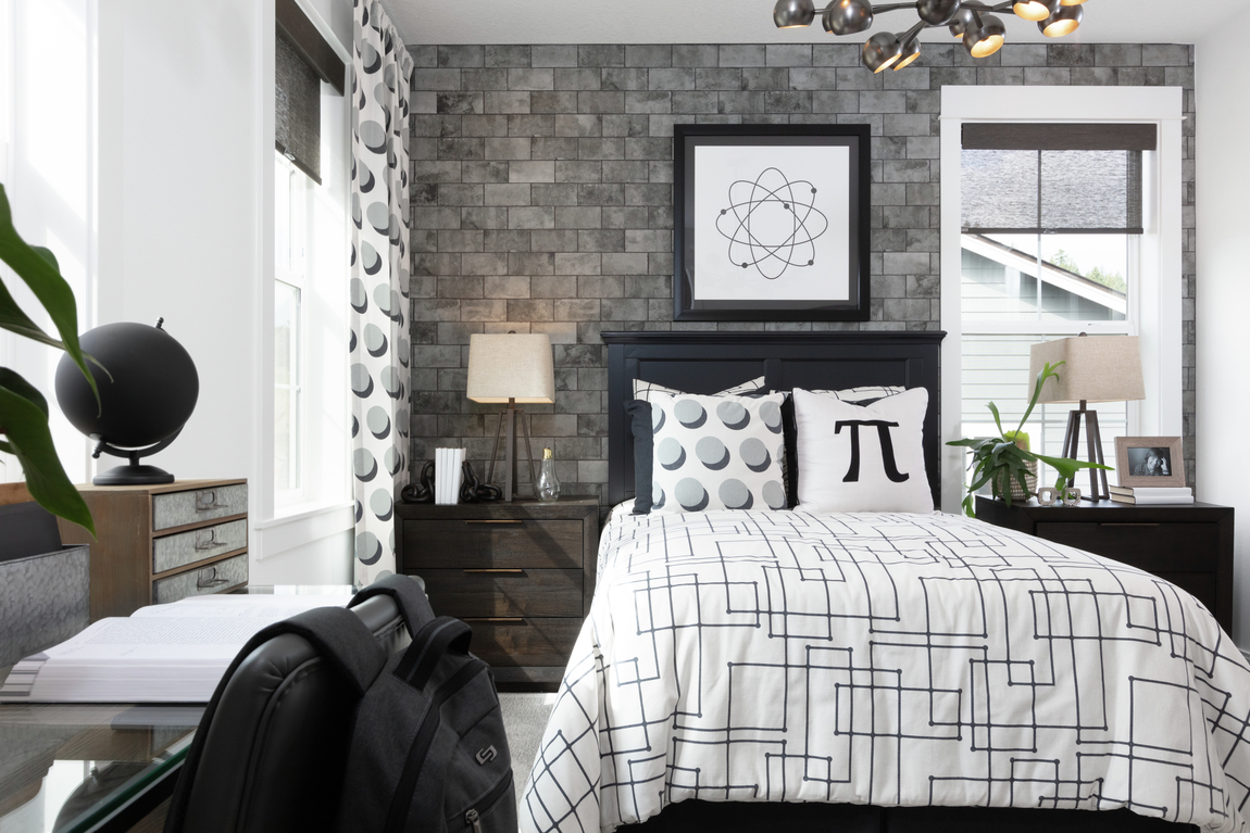 Modern bedroom design with industrial lighting fixture and brick accent wall