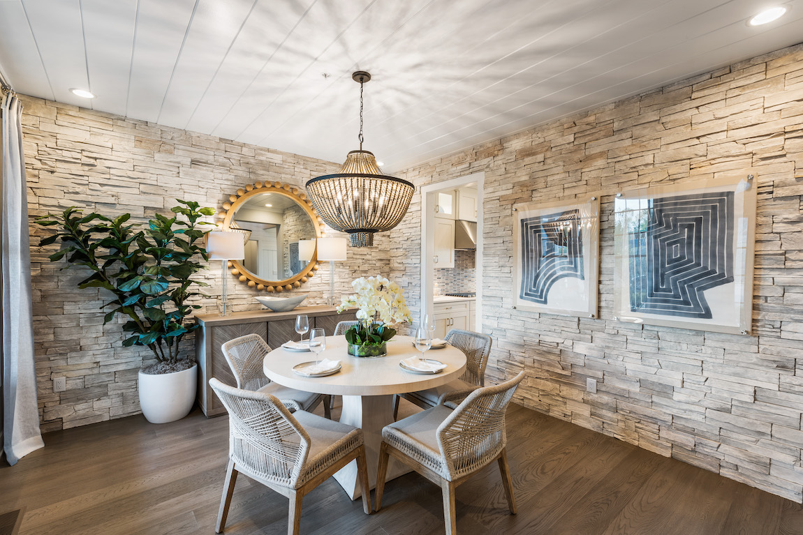 Dining room with coastal design and stone accent wall