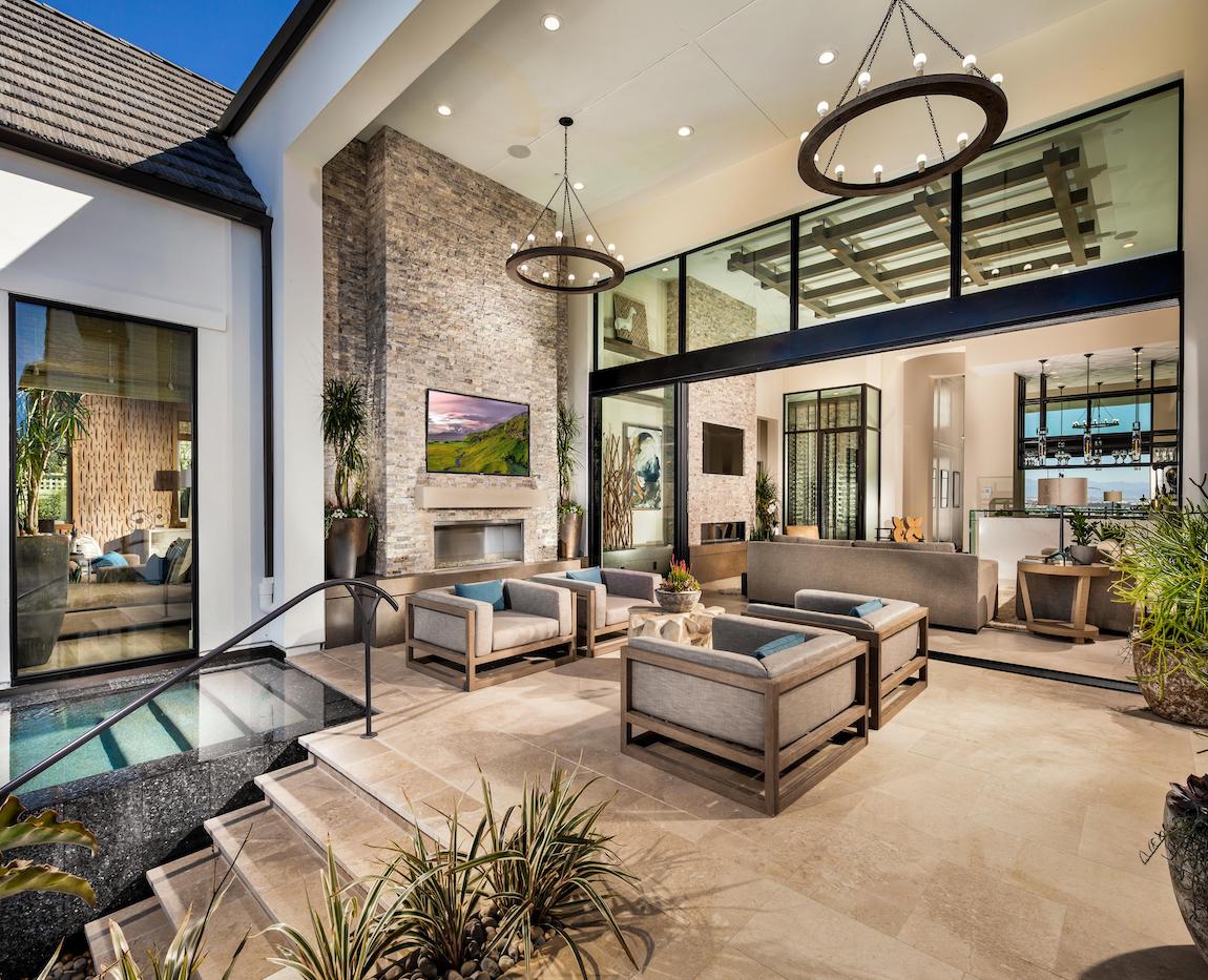 Luxurious indoor/outdoor living area with a fire pit and TV.