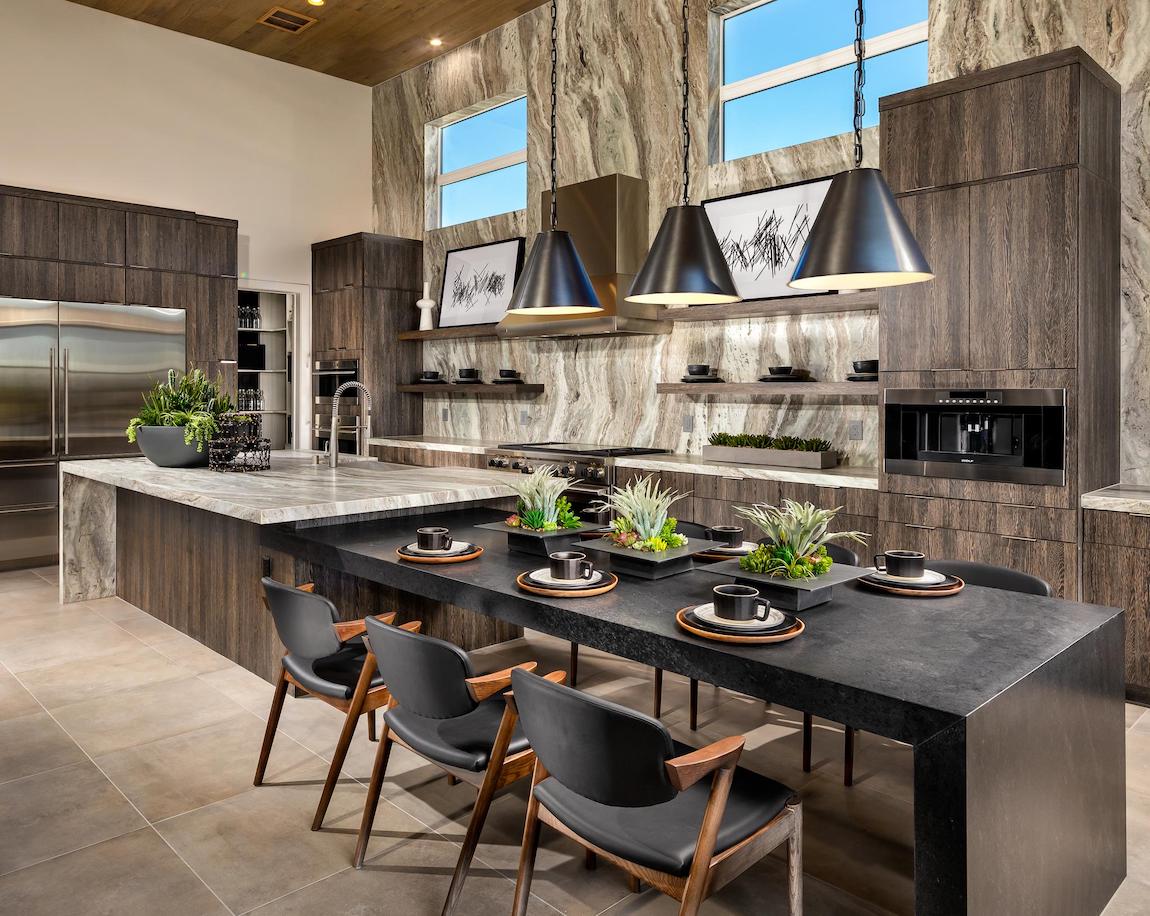 A modern kitchen featuring natural elements such as marble islands, decorative plants, and stone tiles.