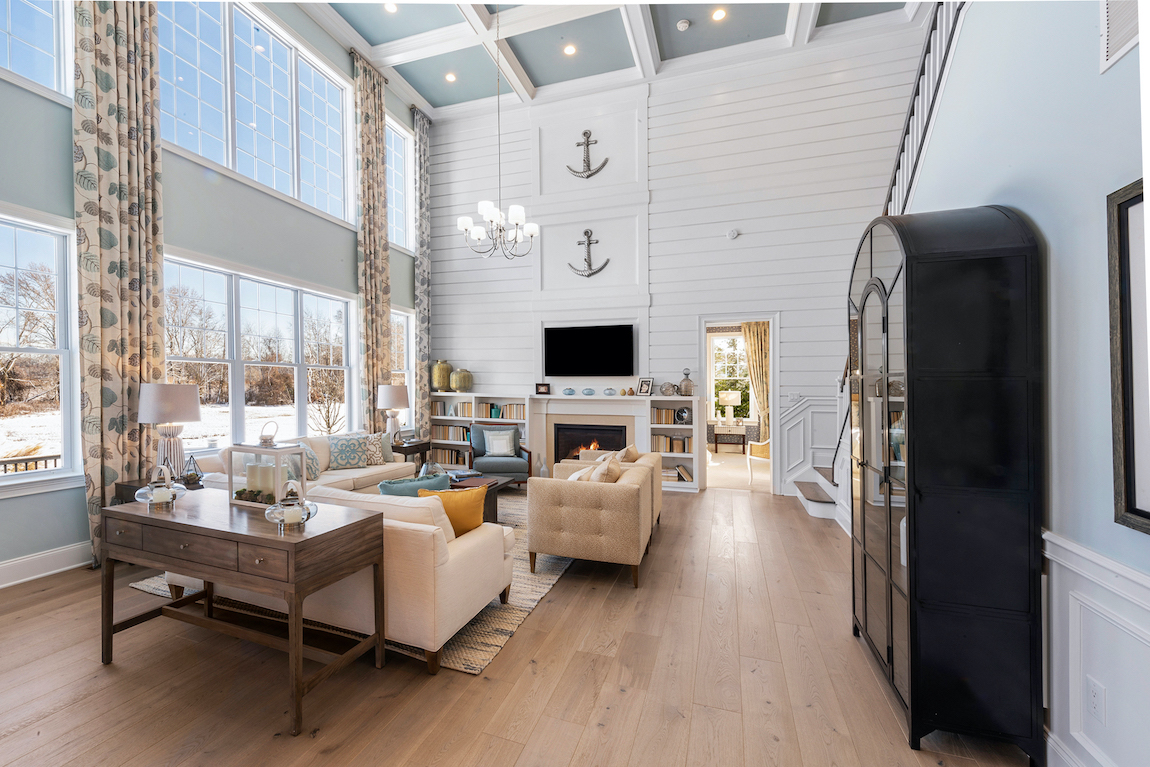 Great room with floor-to-ceiling windows, accent ceiling and shiplap wall with pastel blue theme.