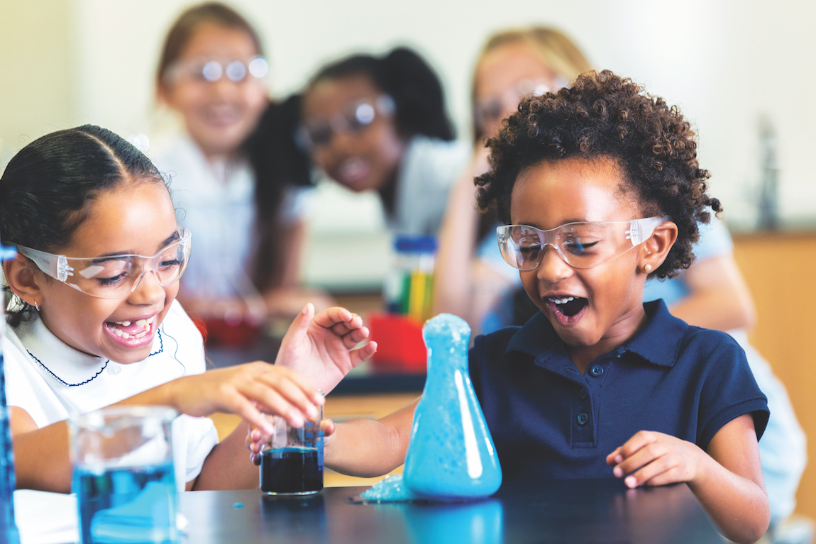 School classmates are excited as foam overflows from beaker during chemistry experiment.