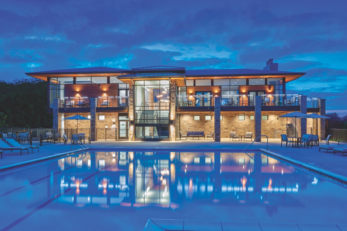 Clubhouse and pool at North Oaks of Ann Arbor lit up at night.