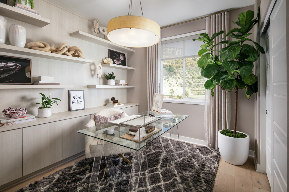 Office highlighted by glass desk and lighting fixture