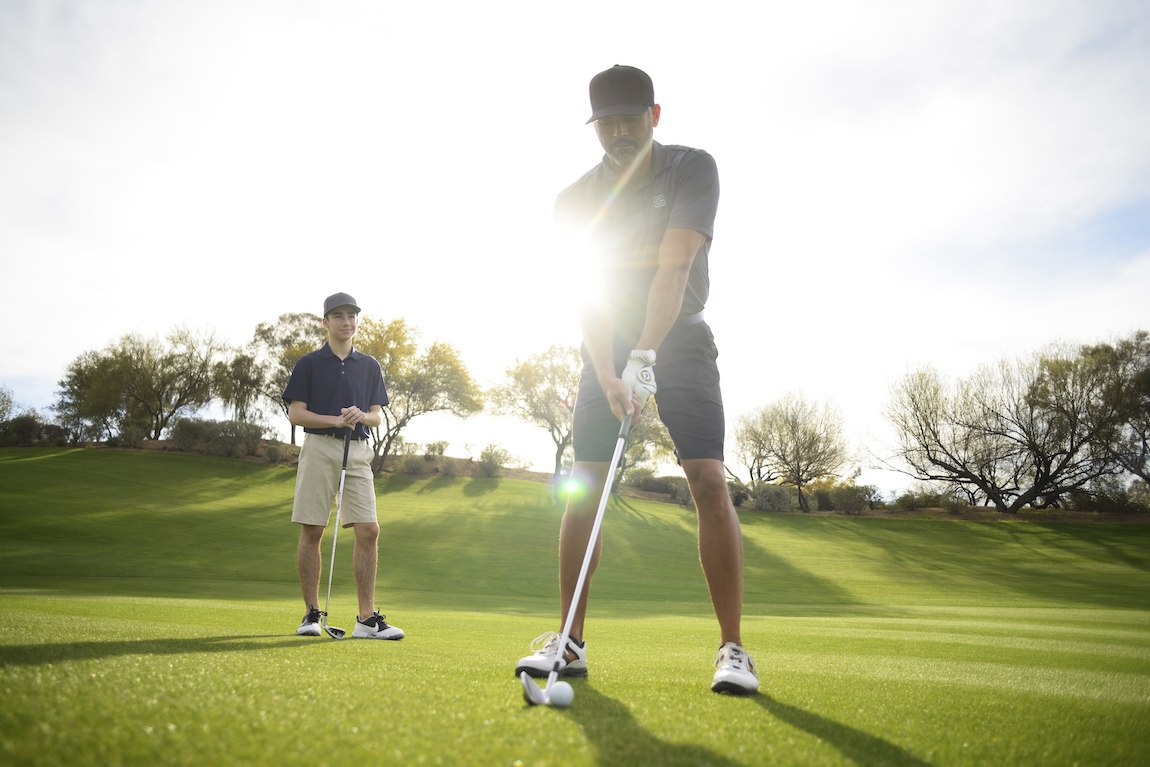 Two men playing golf on a golf course
