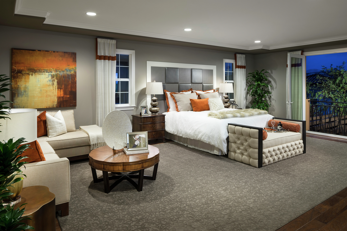 Grey bedroom with orange accents, low wooden coffee table and tufted bed bench