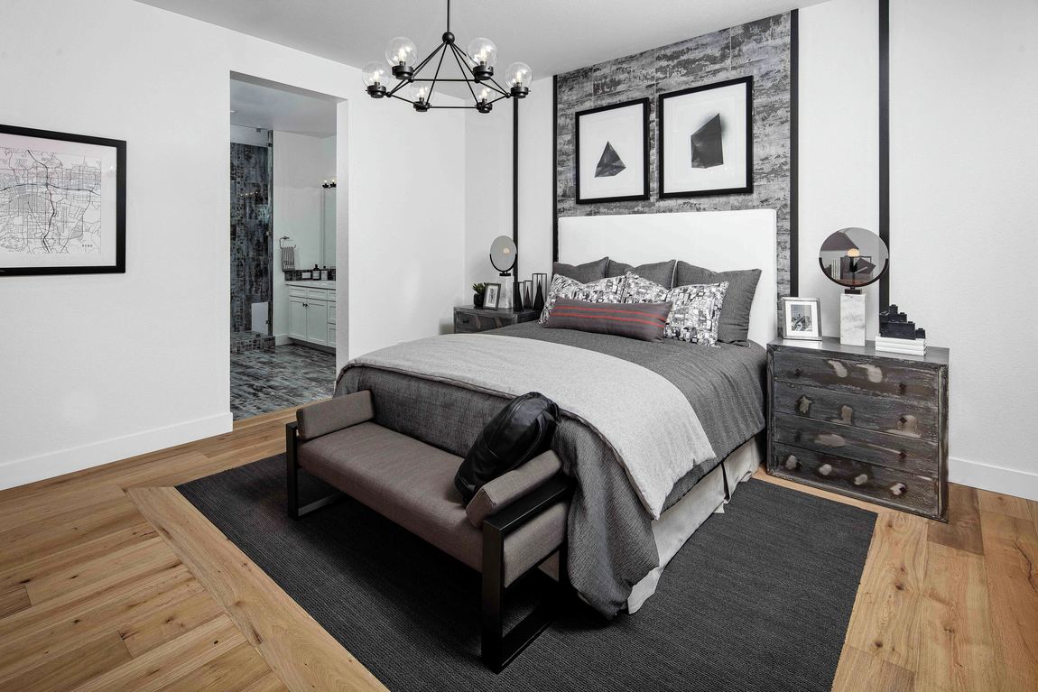 Master bedroom with grey paint color and linens with wood flooring