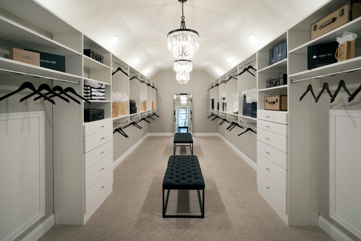 Dual closet with white cabinets and large space for hanging clothes