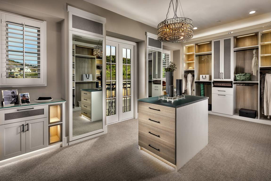 Luxury closet with balcony, center island, jewelry space, floor to ceiling mirror, chandelier, and accent spotlighting