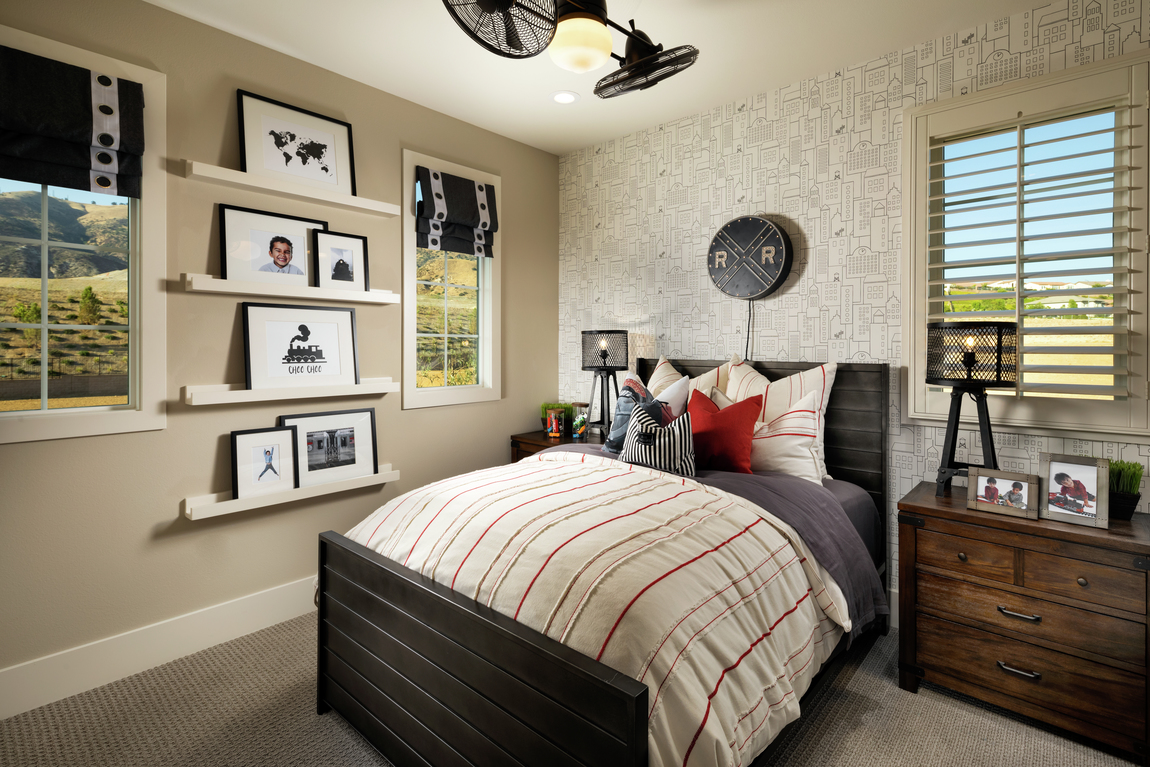 Dual ceiling fan in bedroom with wallpaper and photograph wall