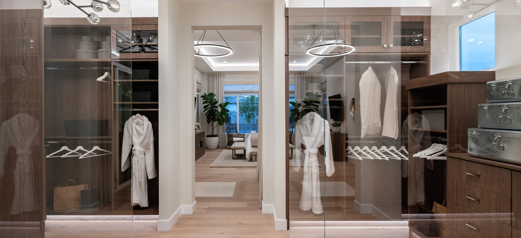 Dual closet with light hardwood floor and connection to bedroom