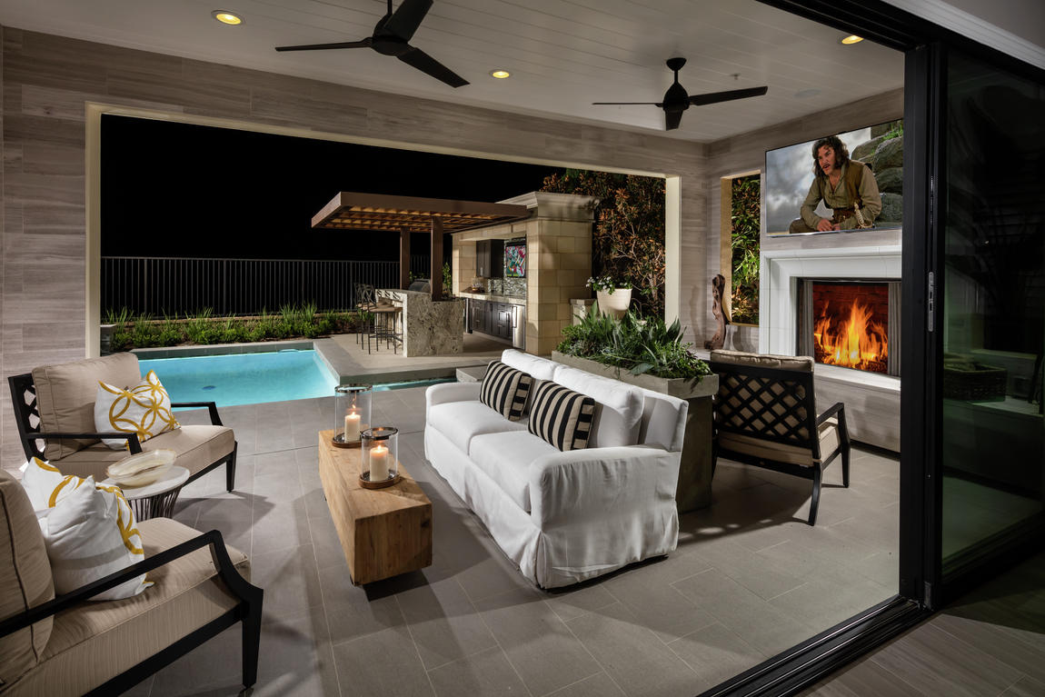 Dual outdoor black ceiling fans over fireplace and couch